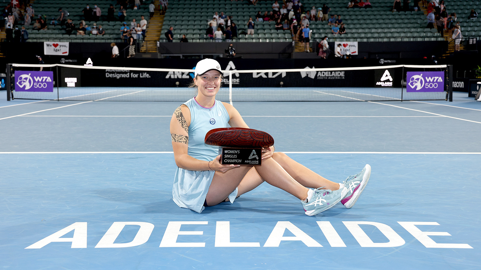 Iga Swiatek celebrates with her trophy after defeating Belinda Bencic in the final of the Adelaide International.